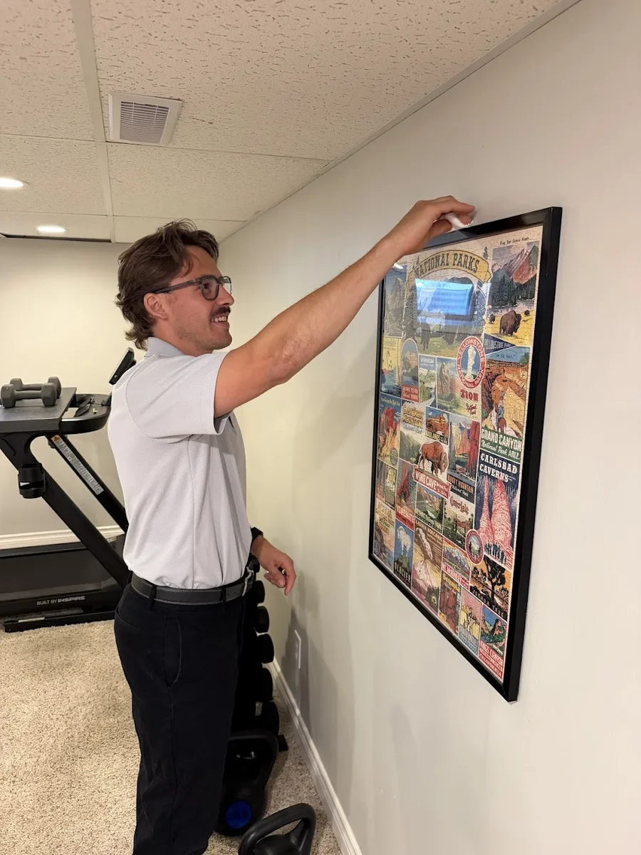 Hunter checking a wall in a home gym during an assessment