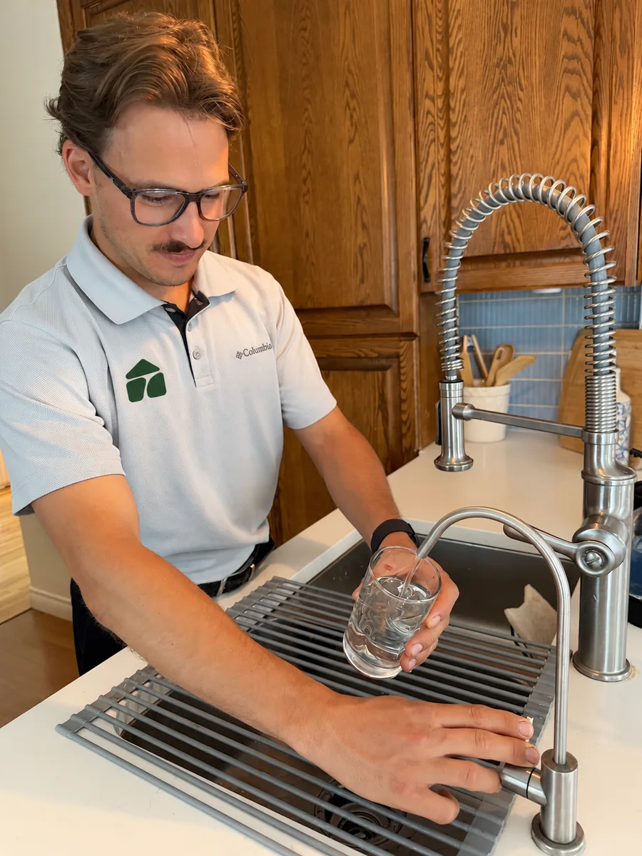 Hunter testing drinking water at a kitchen sink